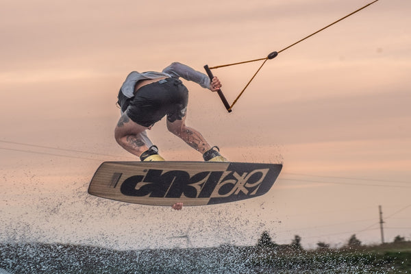 wakeboarding doing a jump during the sunset